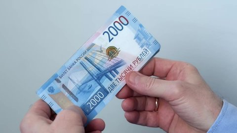 Men's hands count money, the currency is the Russian ruble. Concepts of finance and wealth. Banknotes of 2000 rubles in the hands of men. Investments, saving money.