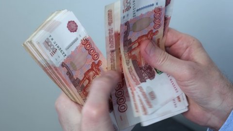 Close-up of hands counting five-thousandth banknotes of the Russian ruble. Men's hands count Russian money 5000 banknotes. business, finance