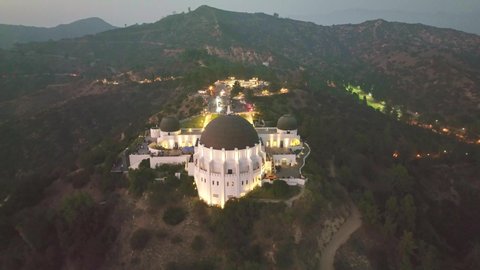 LOS ANGELES, CA, USA - March 15, 2022: Drone aerial shot 4k. Griffith observatory. Los Angeles skyline at night. California landmark, travel destination in America. popular tourist city in USA.