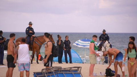 Fort Lauderdale, FL, USA - March 20, 2022: Police on horses cleaning off Fort Lauderdale Beach tourists Spring Break 2022