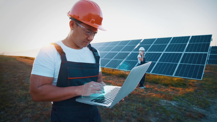 Engineer or construction worker asian man uses laptop to check solar panel system status. Cell power plant. Augmented reality concept. Futuristic technology Royalty-Free Stock Footage #1088688595