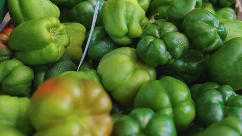 Green, Yellow, and Red Bell Peppers for sale at a farmers market closeup