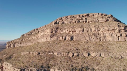 Drone aerial fly-by of a large cliff face with layers of rock and washout