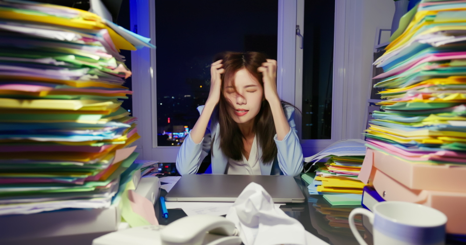 Asian angry young businesswoman is overworking and hitting her laptop because business is failure at night | Shutterstock HD Video #1088693661