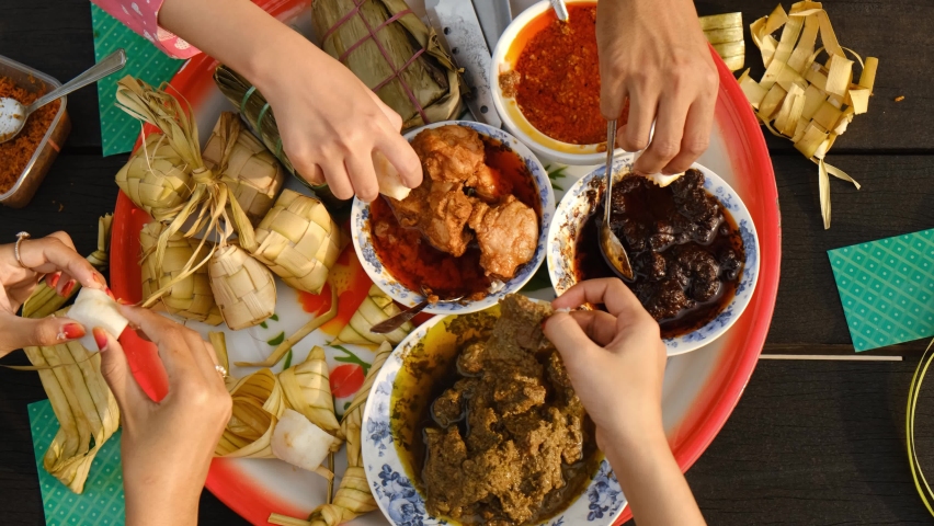 Top down handheld footage of hand taking "Hari Raya" festival. Famous traditional food ketupat, rendang, ayam masak merah and many more. | Shutterstock HD Video #1088693909