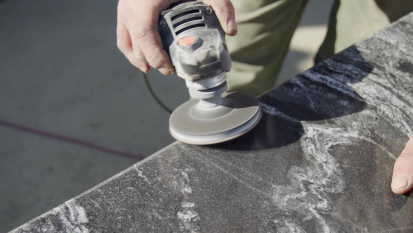 The master works with a stone using a grinder. It smooths out the bevel. Close-up. Royalty-Free Stock Footage #1088696121