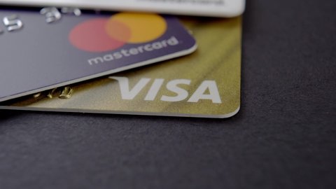 Spain, Oviedo, 15 March, 2022: Visa and Mastercard bank credit cards close-up. Selective focus. On a black background. Rotation. Macro