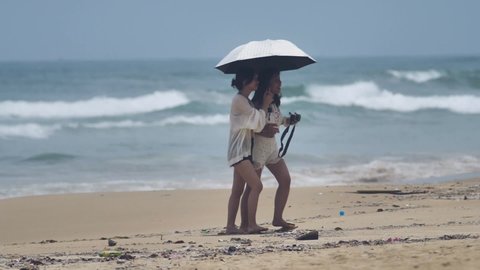 Da Nang City, Vietnam- 05 10 2021: Asian women with umbrella at the beach.