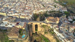 scenic Spanish town of Ronda at sunset, aerial view of Spanish white village of Ronda with famous Puente Nuevo bridge. High quality 4k footage