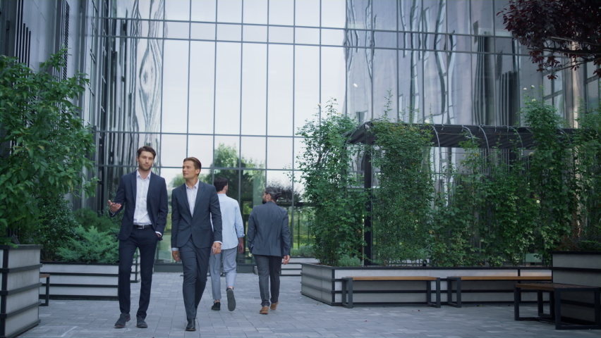 Two successful businessmen walking at modern office building discussing project. Focused handsome men financial managers talking lawyers going to client meeting in suits. Corporate people lifestyle. Royalty-Free Stock Footage #1088700829