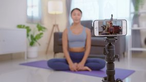 Professional yoga coach teaching online training class to students during live streaming on social media, healthcare concept

