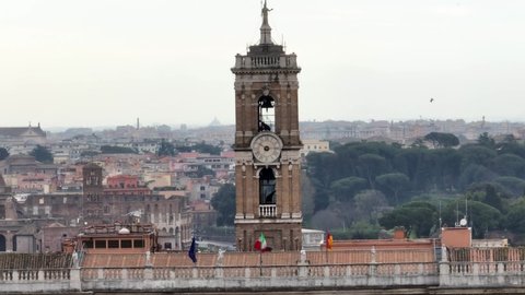 The Campidoglio clock, overlooking the Roman Forum and Colosseum in Rome.
Closeup of the bell tower with the clock, aerial view.