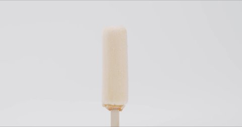 Time-lapse melting ice cream on a stick on white background.