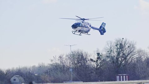 KIEV, UKRAINE. 15 DECEMBER 2021: Ukrainian police helicopter is landing on the airfield cover in snow. High quality 4k footage