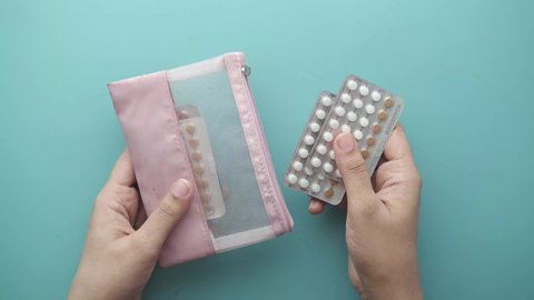 women hand holding birth control pills close up 