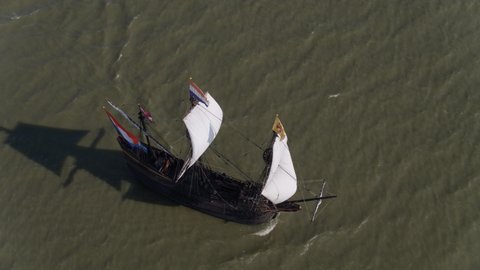 An aerial footage revolving around the Halve Maen ship at the middle of the sea. This is a replica of the ship made by the Dutch East India Company and was commissioned by the VOC Chamber of Amsterdam