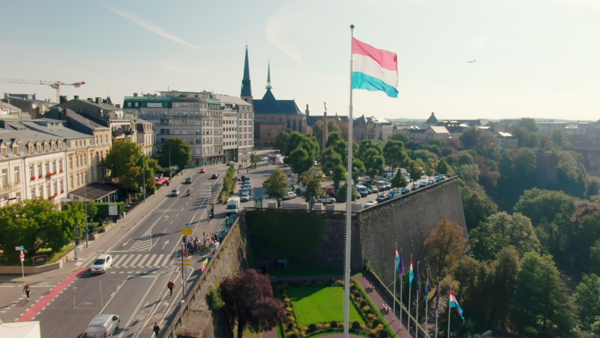 Establishing Aerial shot of Luxembourg Cityscape Panorama with Landmark Skyline and National Flag Waving on Wind. Tourism, Travel or Urban b-roll Background. 4K drone zoom in shot | Shutterstock HD Video #1088716567