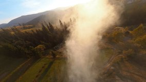 Aerial cinematic video of foggy sunrise bright sky in the mountains. Picturesque misty landscape of wild forests. Travel. Journey. FPV drone views.