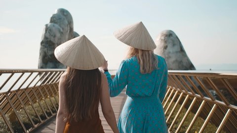 Girls walks wearing  Vietnamese hat on Golden Bridge, Vietnam. Slow motion