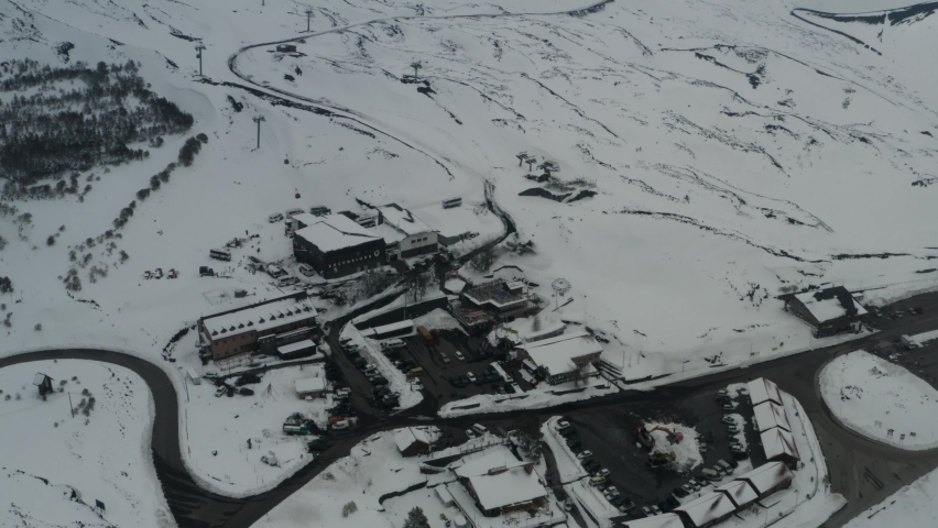 Aerial shot with drone of Etna in winter. Frozen trees and snow-covered craters, Etna in activity, Valle del Bove and summit craters. Snowy woods. South-East, North-East, Sartorius, Bocca Nuova.