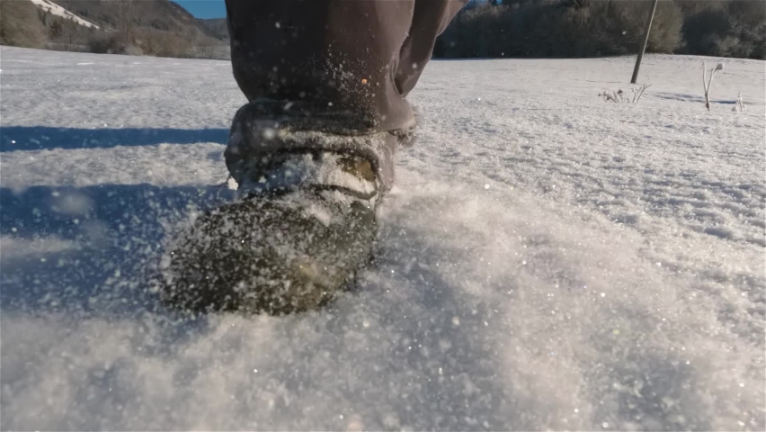 Walk on fresh snow in snow boots towards camera in cold winter sunny morning nature