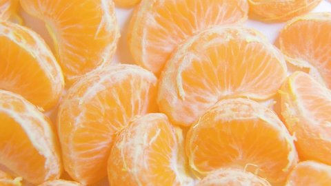 close up many colorful vibrant fresh citrus fruit tangerine, on slow rotating surface, macro round fresh juicy orange citrus tangerines rotate