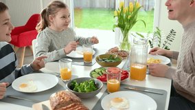 Happy family having healthy breakfast at home. 4k slow motion video