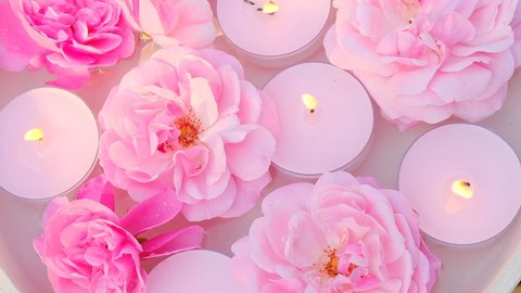 Flower candles.rose candle.Aromatherapy and spa Candles with rose scent.Rose scented candles.Pink burning candles and pink roses in water. High quality 4k footage
