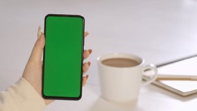 Handheld Camera: Back View of Brunette woman Holding Chroma Key Green Screen Smartphone Watching Content Without Touching or Swiping