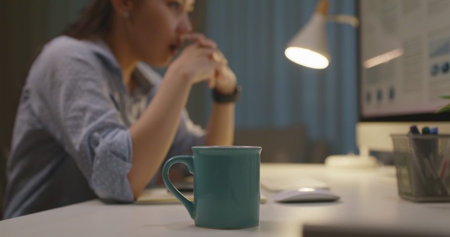 Asia people young woman study hard overnight bored remote learn online read data tired busy sit at home office desk workplace drink energy tea coffee cup thinking worry in job tough stress workforce. Royalty-Free Stock Footage #1088732069