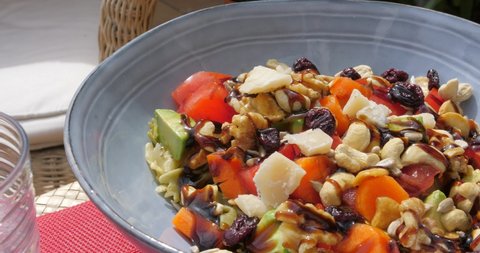 Bowl Of Fresh Vegetable Salad With Balsamic Sauce And Chopped Cashew Nuts. close up