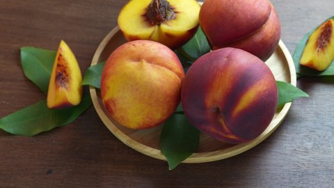 Yellow Peach with slice on Bamboo basket in wooden background, Fresh Yellow Peach with slice in Bamboo basket on wooden table.