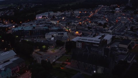 Aerial shot of city centre. Buildings and streets in evening. Cars driving on road and parking in square. Killarney, Ireland