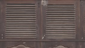 Antique wooden doors in colonial style. Beautiful wooden doors. Old wooden surface. Detail of hinge on old wooden door in historical city. 120 fps video, ProRes 422, 10 bit, ungraded C-LOG