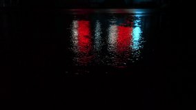 Red, blue and white neon lights are reflected on the wet road during the rain, raindrops fall into colorful puddles on dark night, copy space - Powered by Shutterstock - Get 15% off with code: PIKWIZARD15