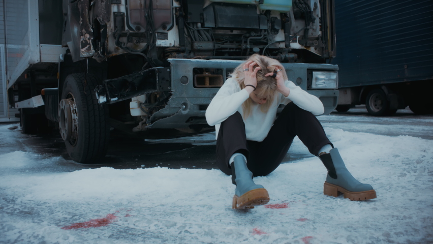 Young Caucasian Girl Sitting On The Floor Covered In Bruises and Blood Stains as She Looks Scared and Shocked, Looking Directly at the Camera. 