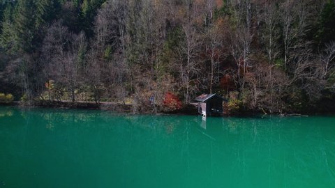Wide Drone Flight Arcing Over Sunlit Klammsee Reservoir With Boathouse In Autumn, Kaprun, Salzburg, Austria