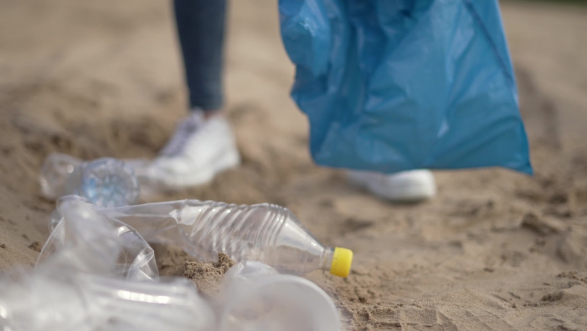 Teamwork family work. Children collect plastic garbage in bags. Kid learn to clean up plastic bottles. Environmental problems. Family of volunteers cleaning up plastic trash on beach.Garbage pollution Royalty-Free Stock Footage #1088755437