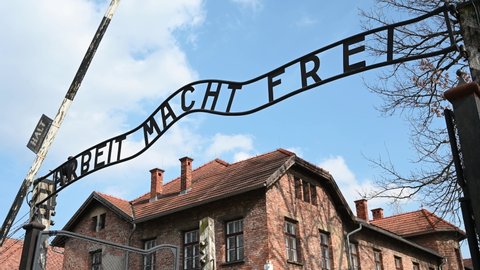 Oświęcim, Poland, March 2022: Auschwitz concentration and extermination camp. Gate to Auschwitz I with "Arbeit macht frei" sign (translation: work sets you free). Nazi death camp.