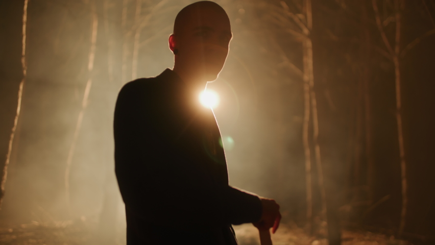 Bald, dangerous man digging a hole with a shovel in the woods at night. Crime scene, hiding a body in the forest. Creepy, thriller scene. | Shutterstock HD Video #1088756521
