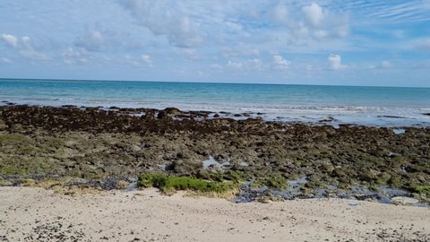 side shot showing black rocks on the beach with blue water beyond at kala pathar beach in havelock swaraj dweep andaman island India a perfect tropical vacation spot