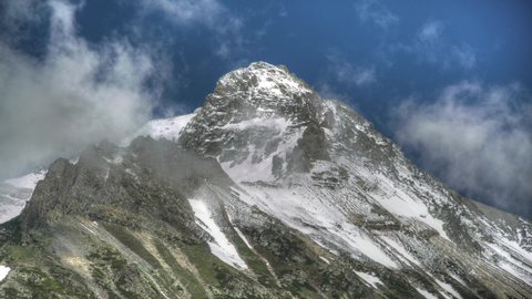 8K 7680X4320.High snowy mountain peak in the shape of a symmetrical pyramid.Time lapse in nature.High altitude mount mountainous imposing terrain geography slope ridge hilly hill hills summit top awe.