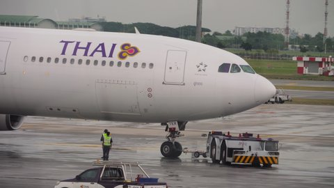 BANGKOK, THAILAND - NOVEMBER 11, 2017: Airbus A330 Thai Airways towing a tractor to the runway at Suvarnabhumi Airport. Tourism and travel concept