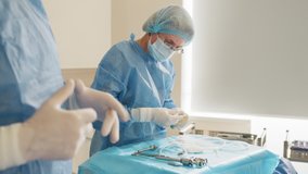 Scrub nurse preparing medical instruments for operation. Close-up Shot in Operating Room of Surgical Table with Instruments, Assistant Picks up Instruments for Surgeons During Operation - Powered by Shutterstock - Get 15% off with code: PIKWIZARD15