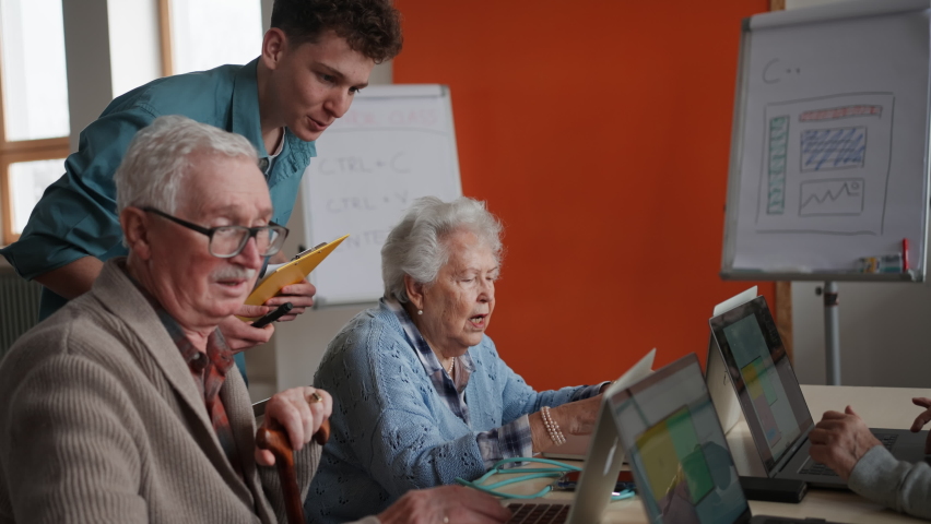 Senior group in retirement home with young instructor learning together in computer class Royalty-Free Stock Footage #1088766455