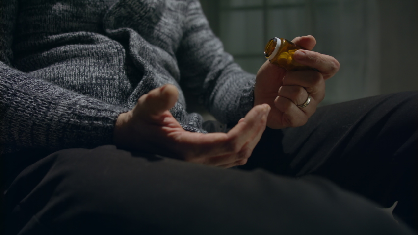 Close-up of man taking drug pill, overdose and mental helath problem concept.