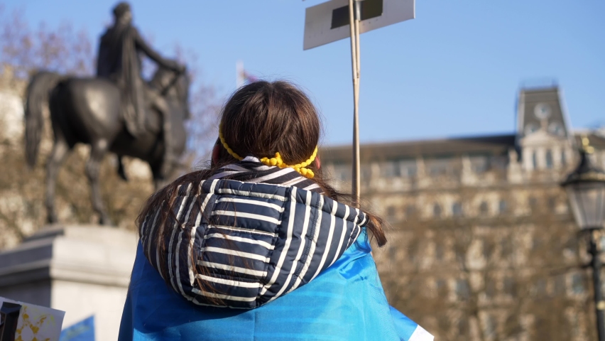 London stands with Ukraine, child protesting waving sign of peace, protester in Trafalgar Square in London during protest against war with Russia
