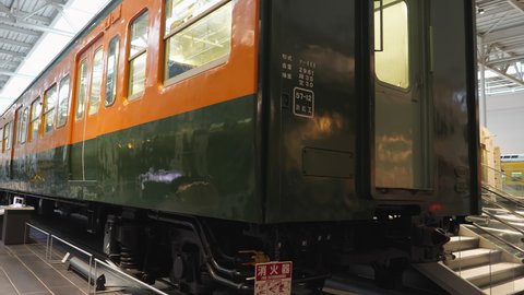 Nagoya.Japan-October 31.2019: Old train wagon displayed in the railway museum in Nagoya Japan. Vintage design. Yellow and green. Camera slowly turning left.