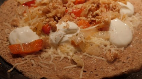 French Buckwheat Crepe With Toppings Cooking On A Non-stick Pan. close up