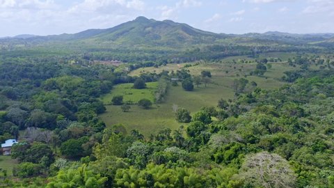 Panoramic View of the Open Fields and Forests with Mountains in the Background in the Bayaguana Dominican Republic - Aerial Panning Shot